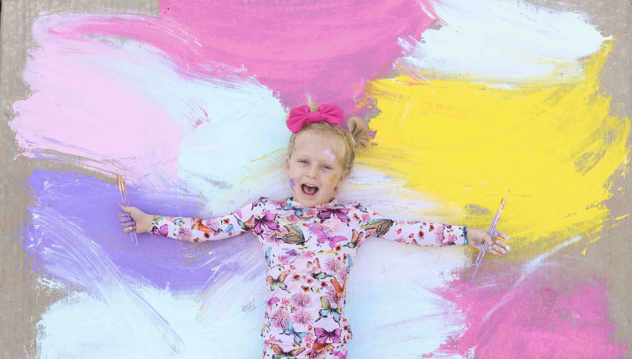 girl laying on rainbow paint