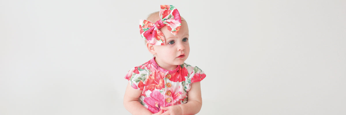 baby girl wearing floral romper with bow