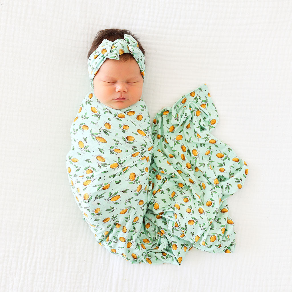 Baby in lemon print swaddle