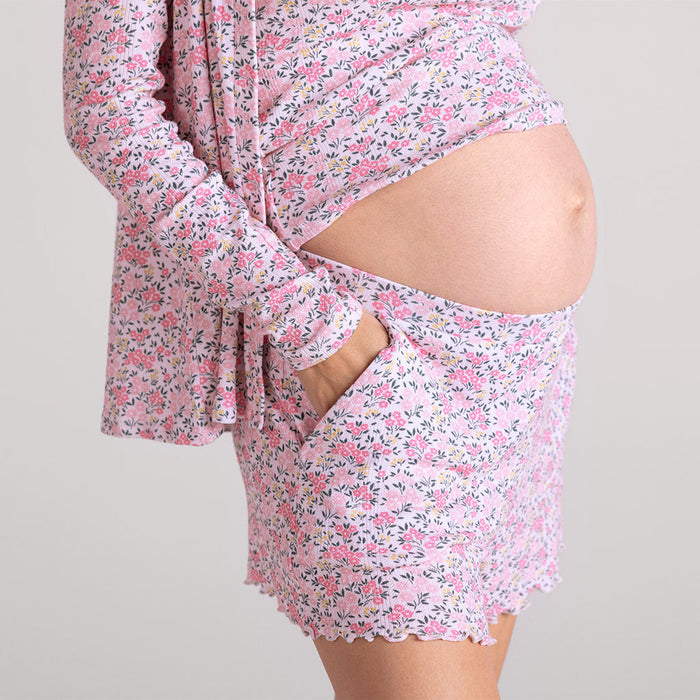 standing pregnant woman wearing pink floral print pajamas