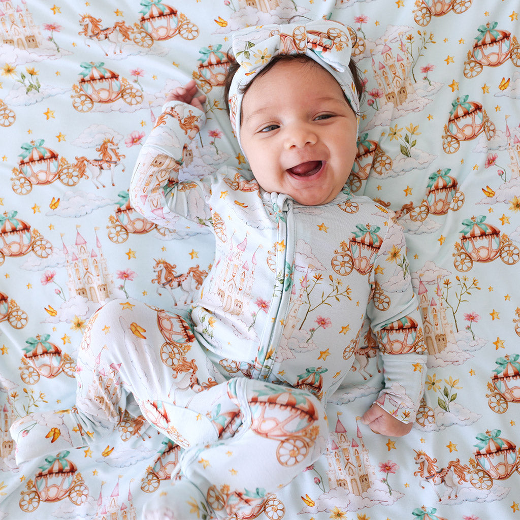 baby lying down wearing whimsy print onesie