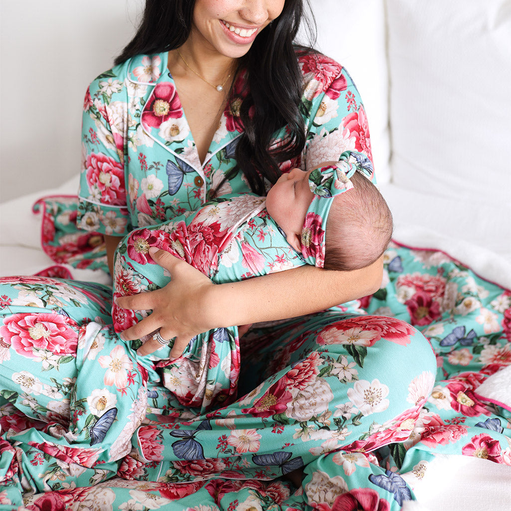 mother holding baby in matching floral print swaddle 