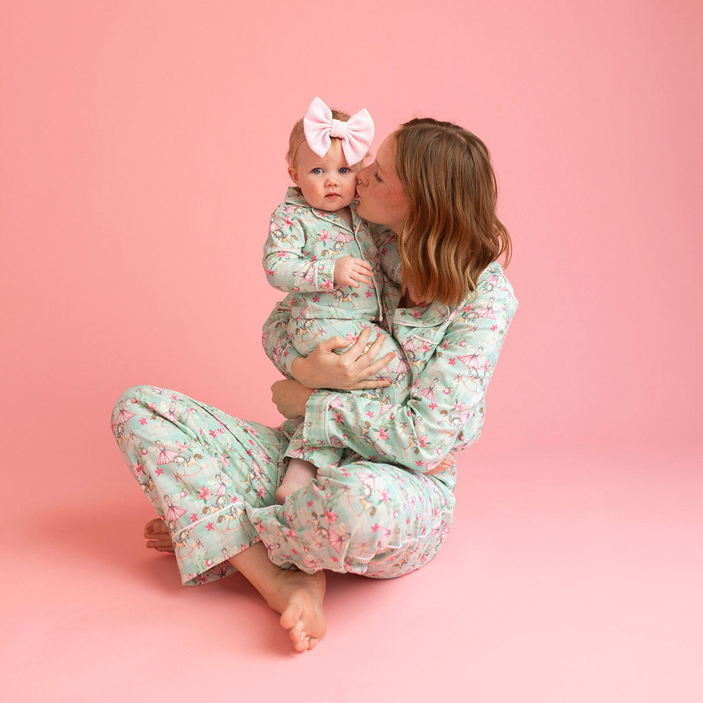 mother sitting embracing child wearing matching whimsy print pajamas