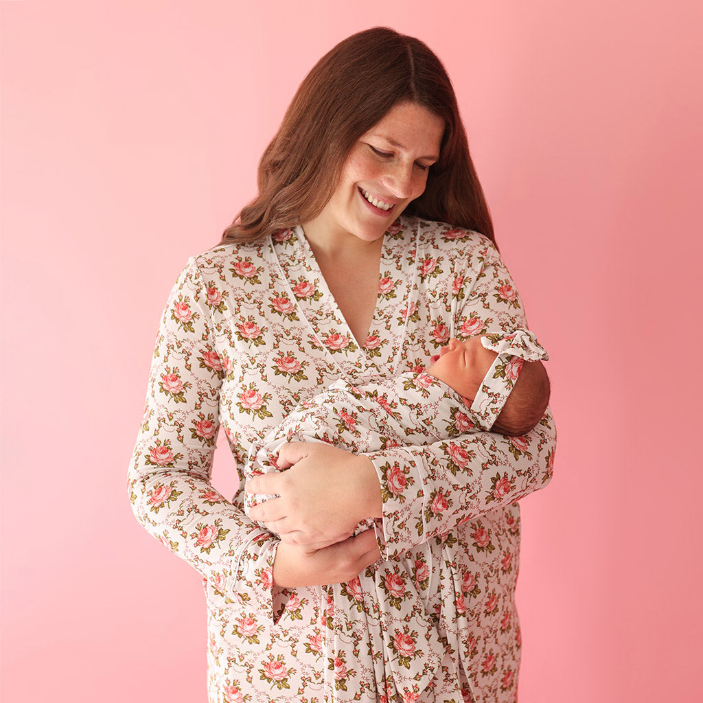 mother holding newborn infant wearing matching floral prints