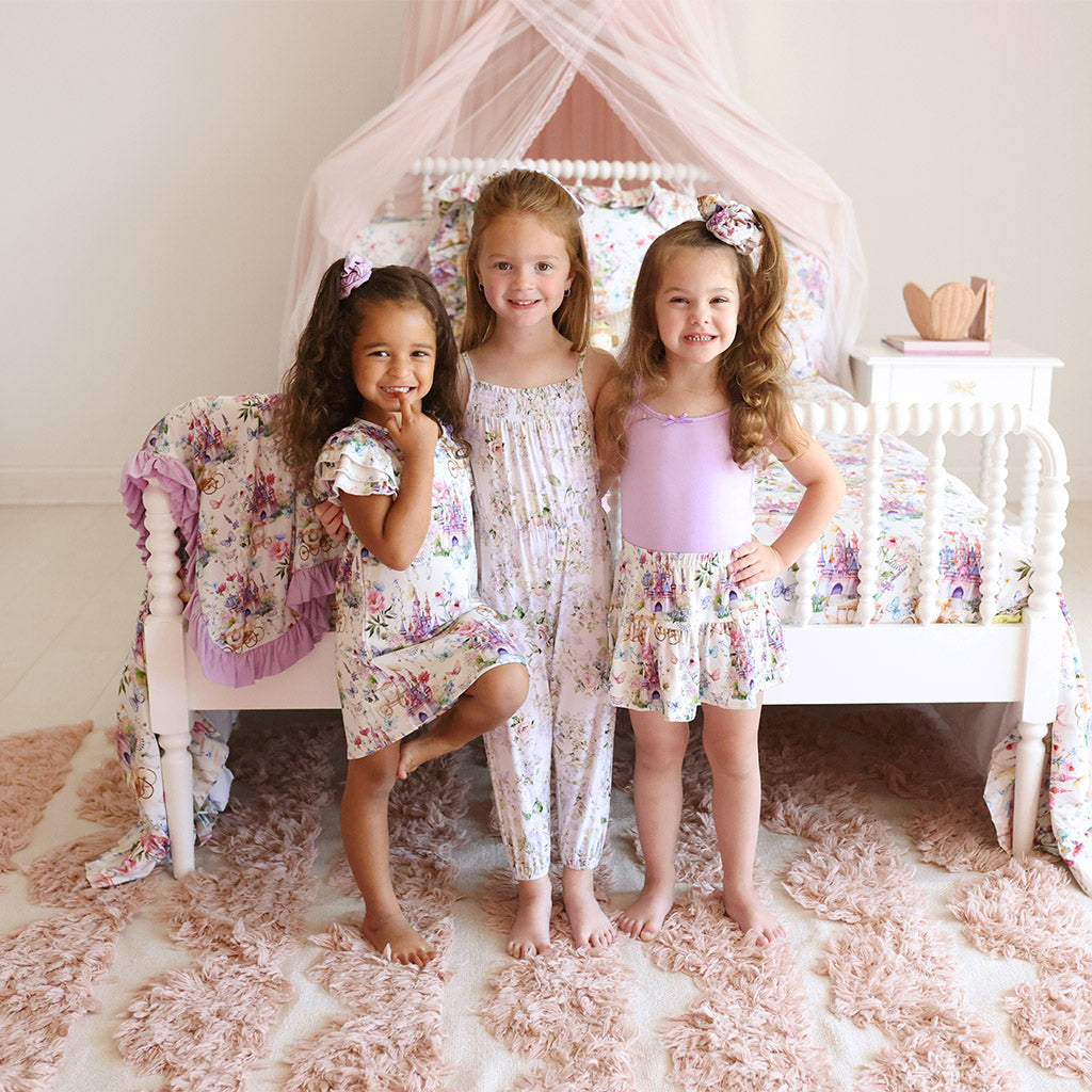 three girls standing in front of bed wearing matching floral print outfits