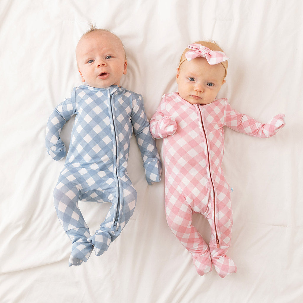 two infants wearing matching gingham print onesies