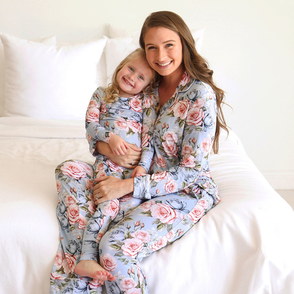 mother holding daughter in lap wearing matching floral print pajamas