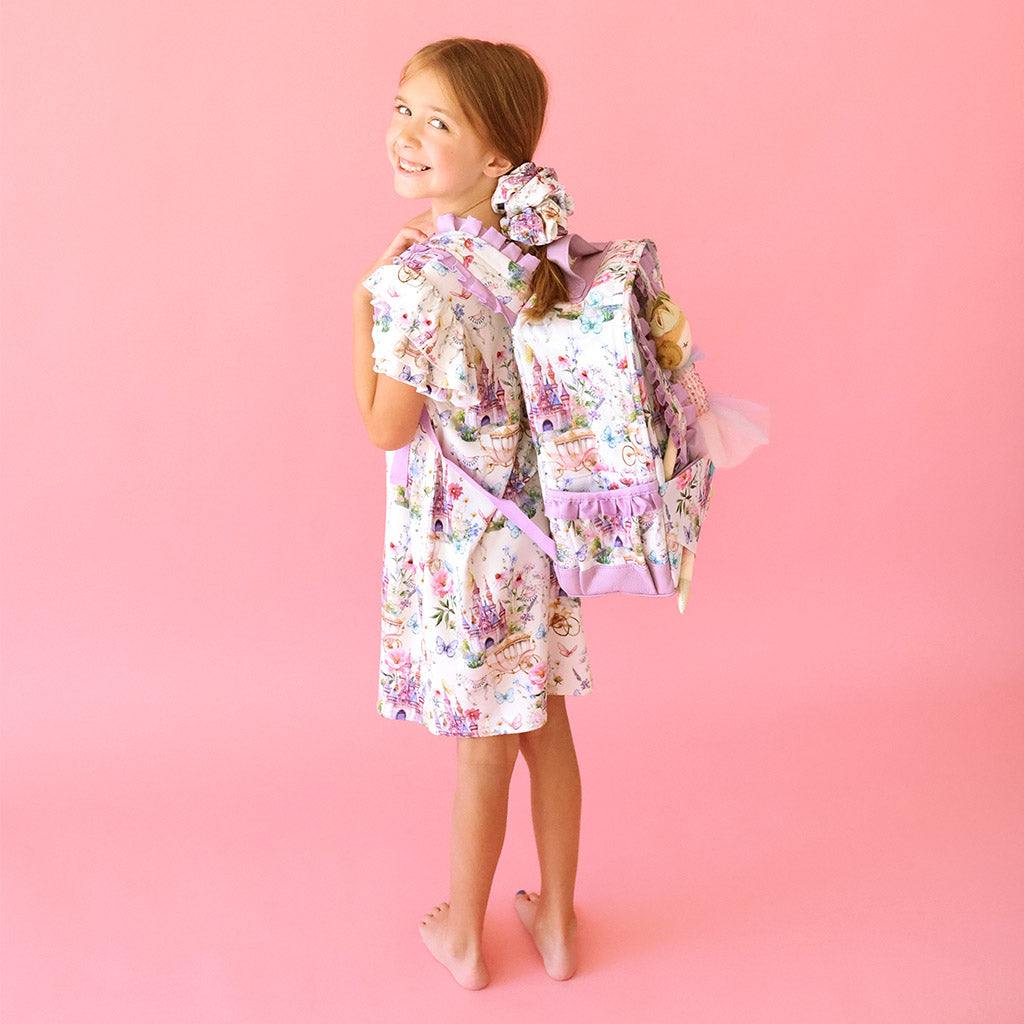 girl wearing whimsy print backpack and matching dress