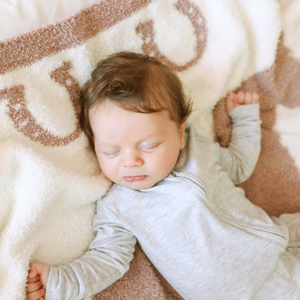 infant laying on cuddle blanket sleeping