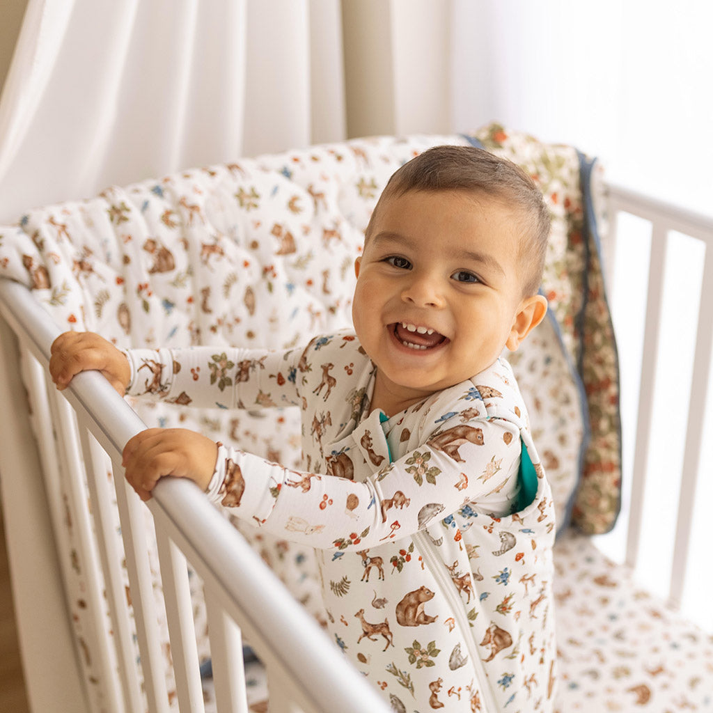 infant in crib gripping onto rail