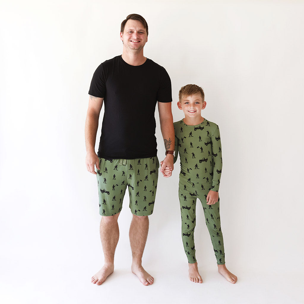 father and son holding hands wearing matching green pajamas