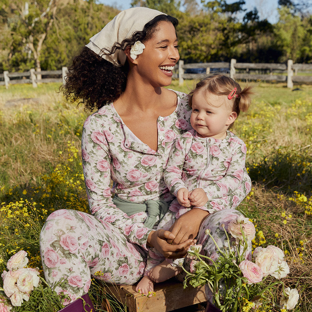 woman and toddler sitting in flowering field wearing matching print floral outfits