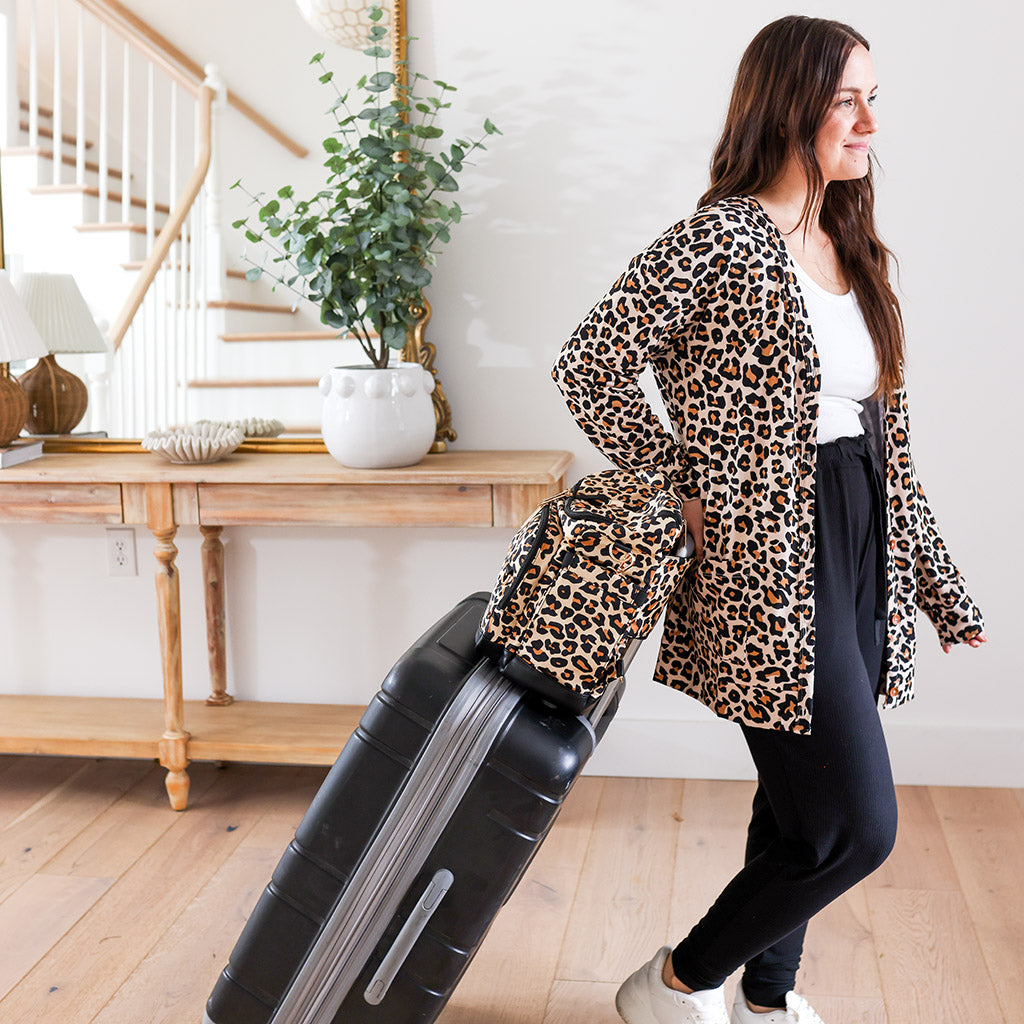 Woman leaving home with matching leopard print luggage 