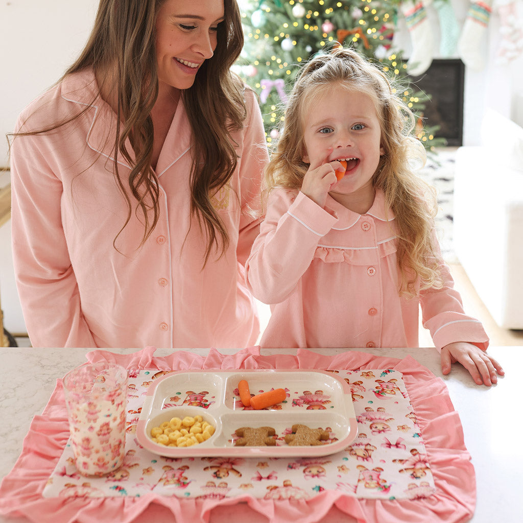 mother and daughter eating in kitchen wearing matching pink pajamas