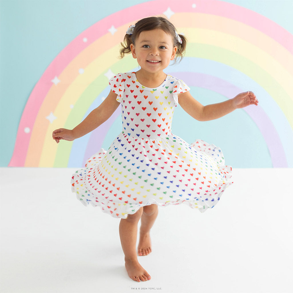 girl wearing twirl dress with rainbow in background