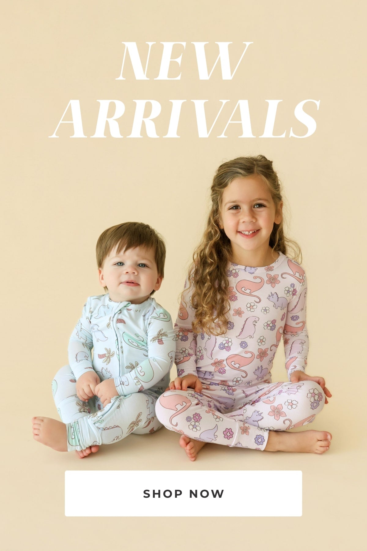 two young children wearing matching pajamas sitting down together with text 'New Arrivals Shop Now' on beige background