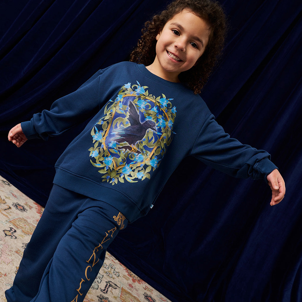 Child wearing a navy blue jogger set with a Harry potter inspired design.
