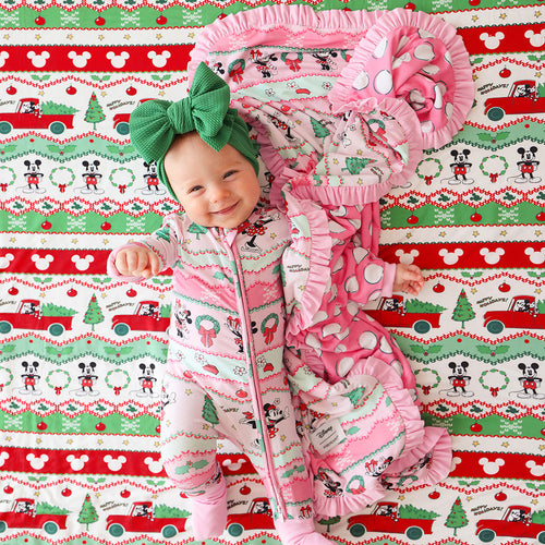 Baby in festive outfit with matching headband on a Christmas-themed blanket