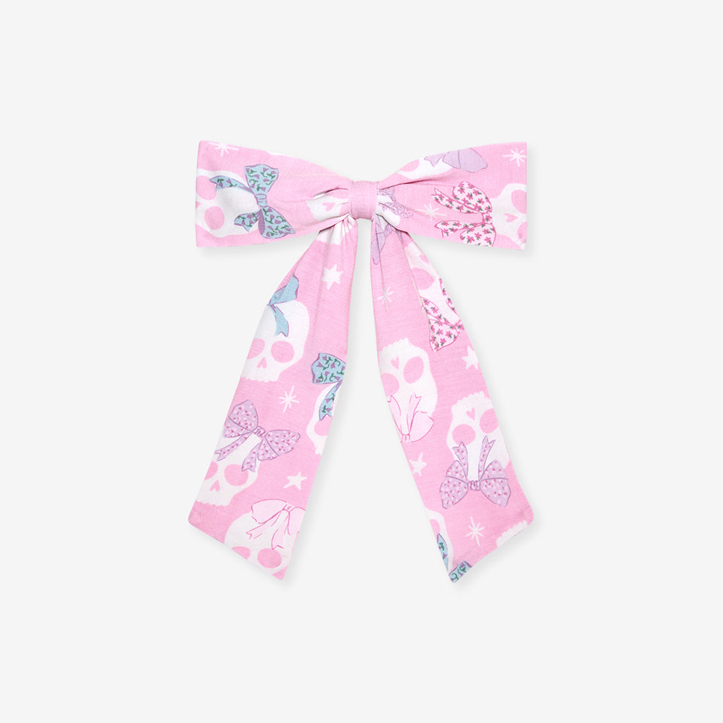 Flat lay of the Posh Peanut Ms. Kelly Luxe Bow Hair Clip, white background