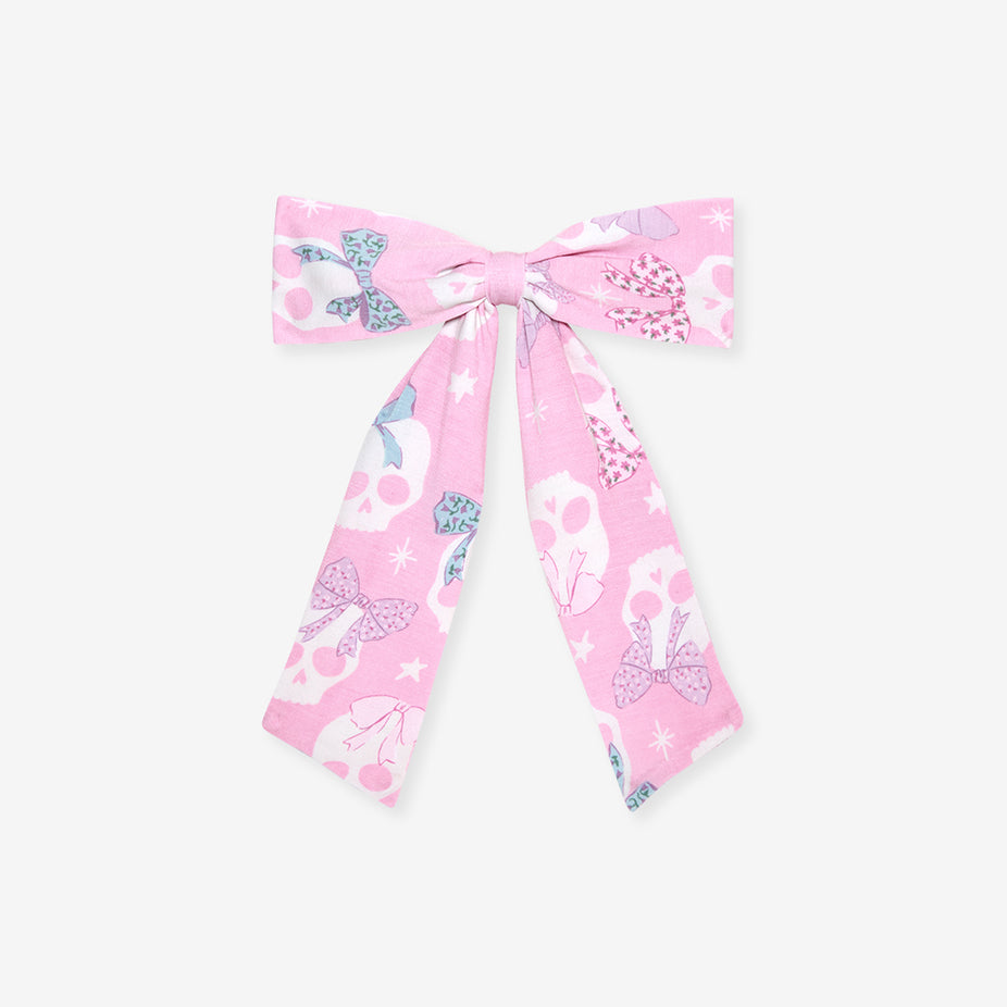 Flat lay of the Posh Peanut Ms. Kelly Luxe Bow Hair Clip, white background