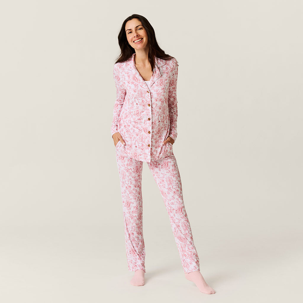 Woman wearing pink floral pajamas on a plain background