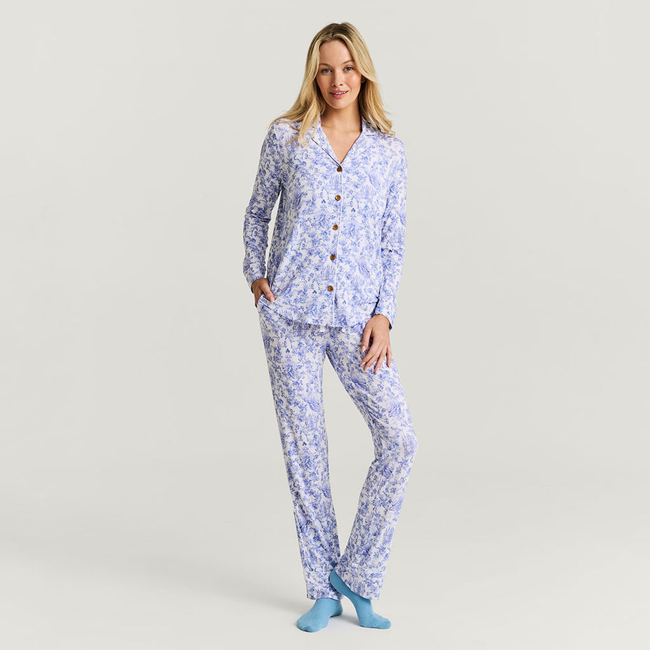 Woman wearing a blue floral pajama set on a light gray background