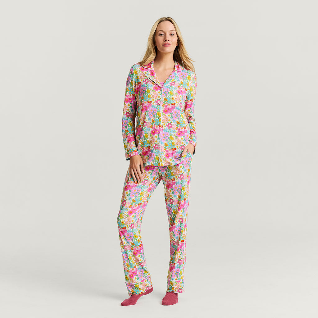 Woman wearing a colorful floral pajama set on a plain background