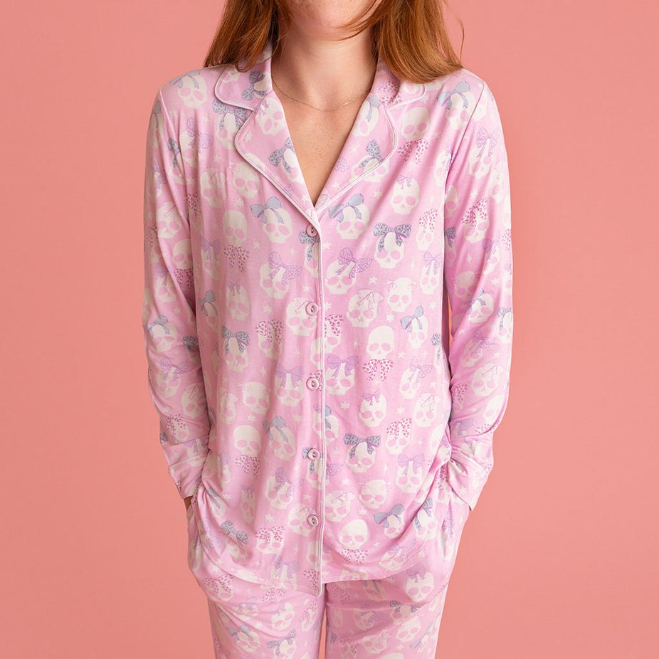 Woman wearing the Posh Peanut Ms. Kelly Women's Luxe Pajama Pant Set, close-up, coral background