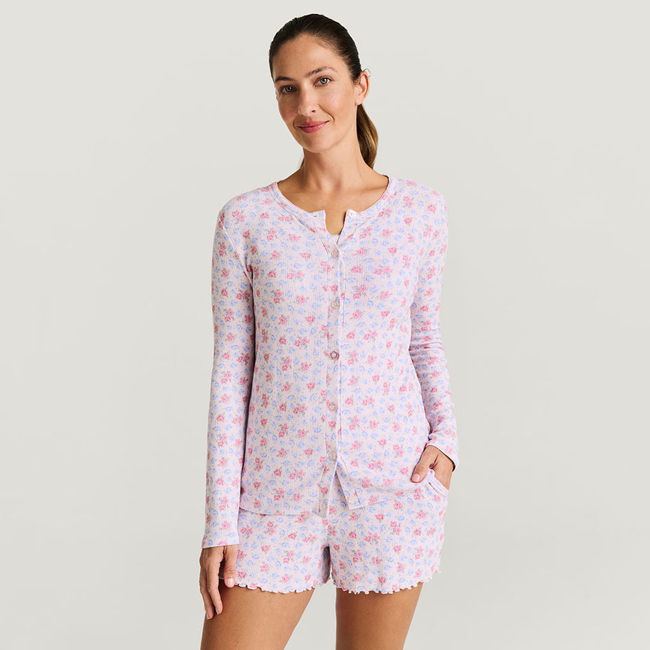 Woman wearing a light pink floral set on a plain background