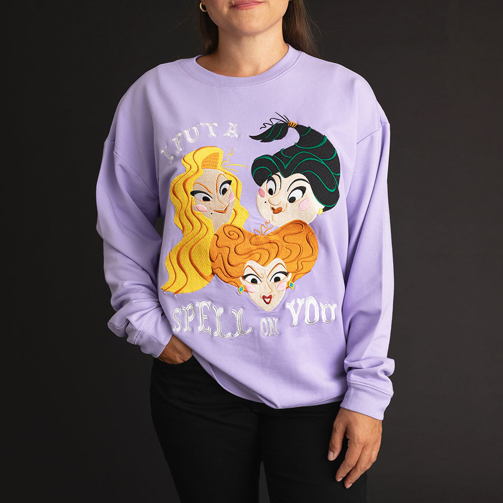 Close-up of a woman wearing the Posh Peanut Disney Sisters Spell Women's Fleece Sweatshirt in lavender, featuring the 