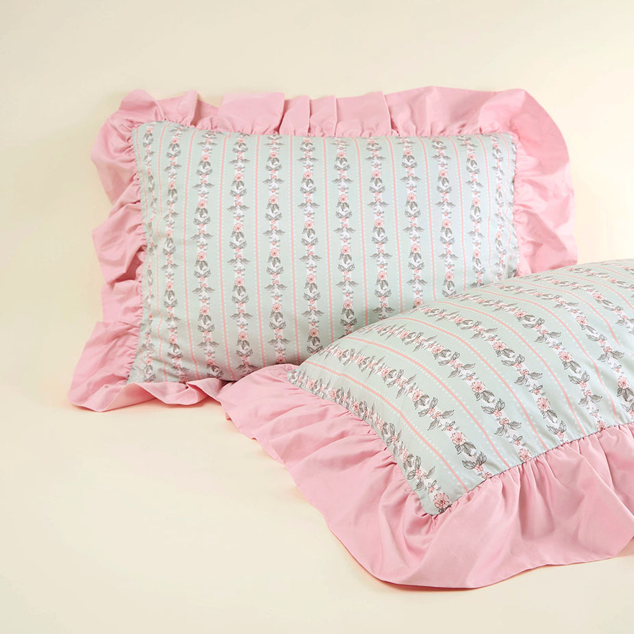 Two decorative pillows with pink ruffled edges on a beige background