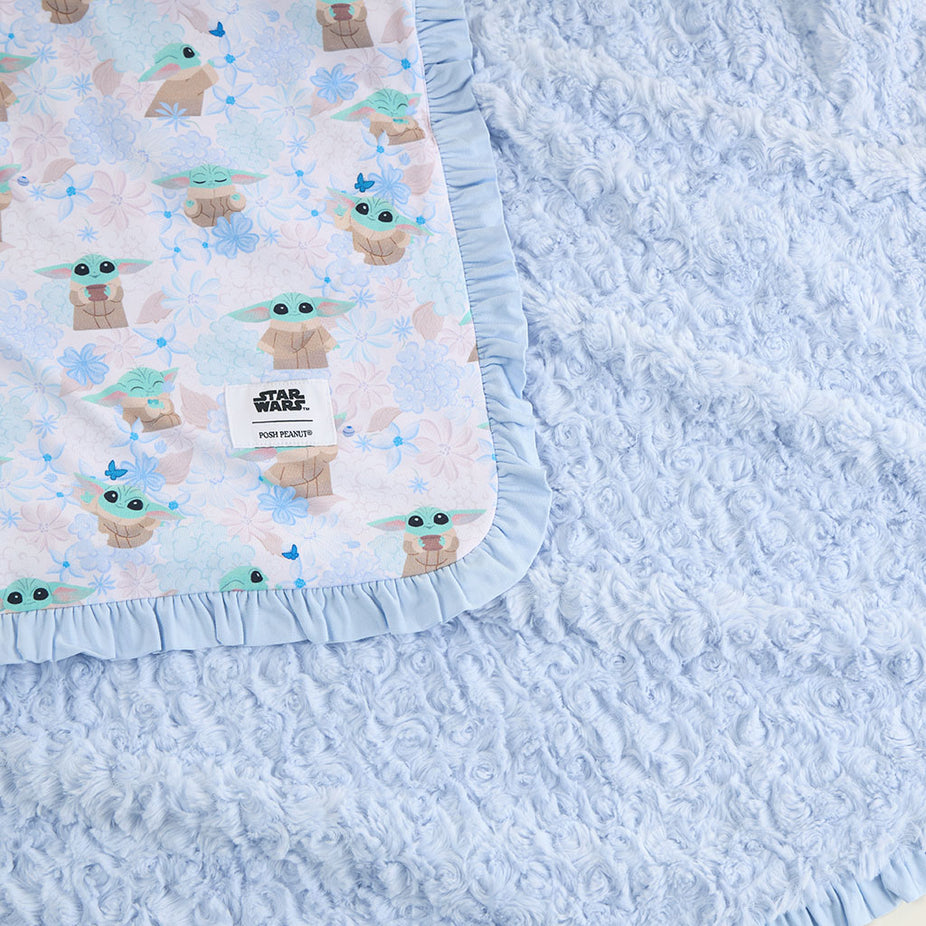 Baby blanket with 'Baby Yoda' pattern on a textured blue surface