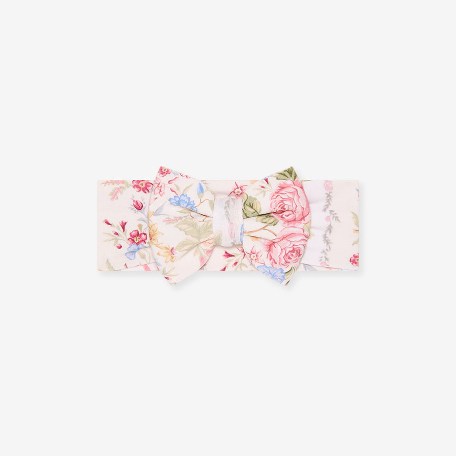Flat lay of the Janey print luxe bow headwrap on a white background