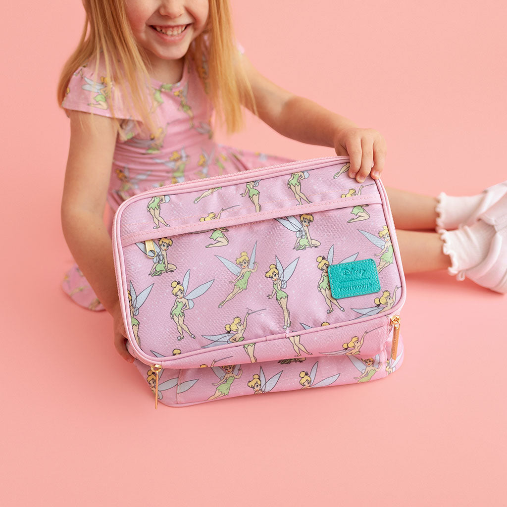 Child holding a pink Tinkerbell-themed lunch bag on a pink background