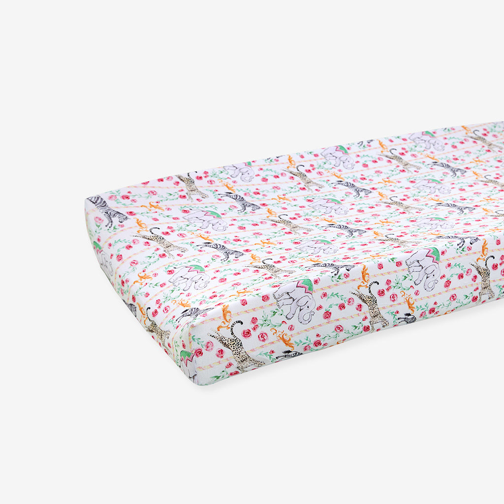 Floral and animal patterned crib sheet on a white background
