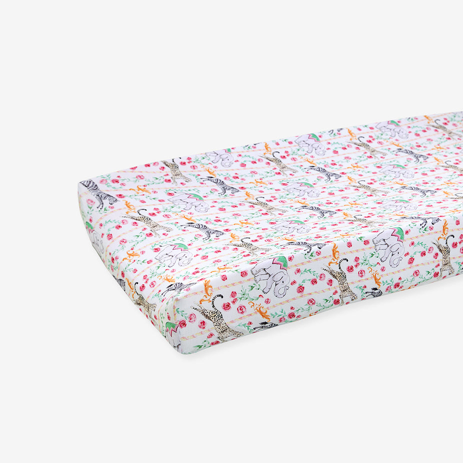 Floral and animal patterned crib sheet on a white background