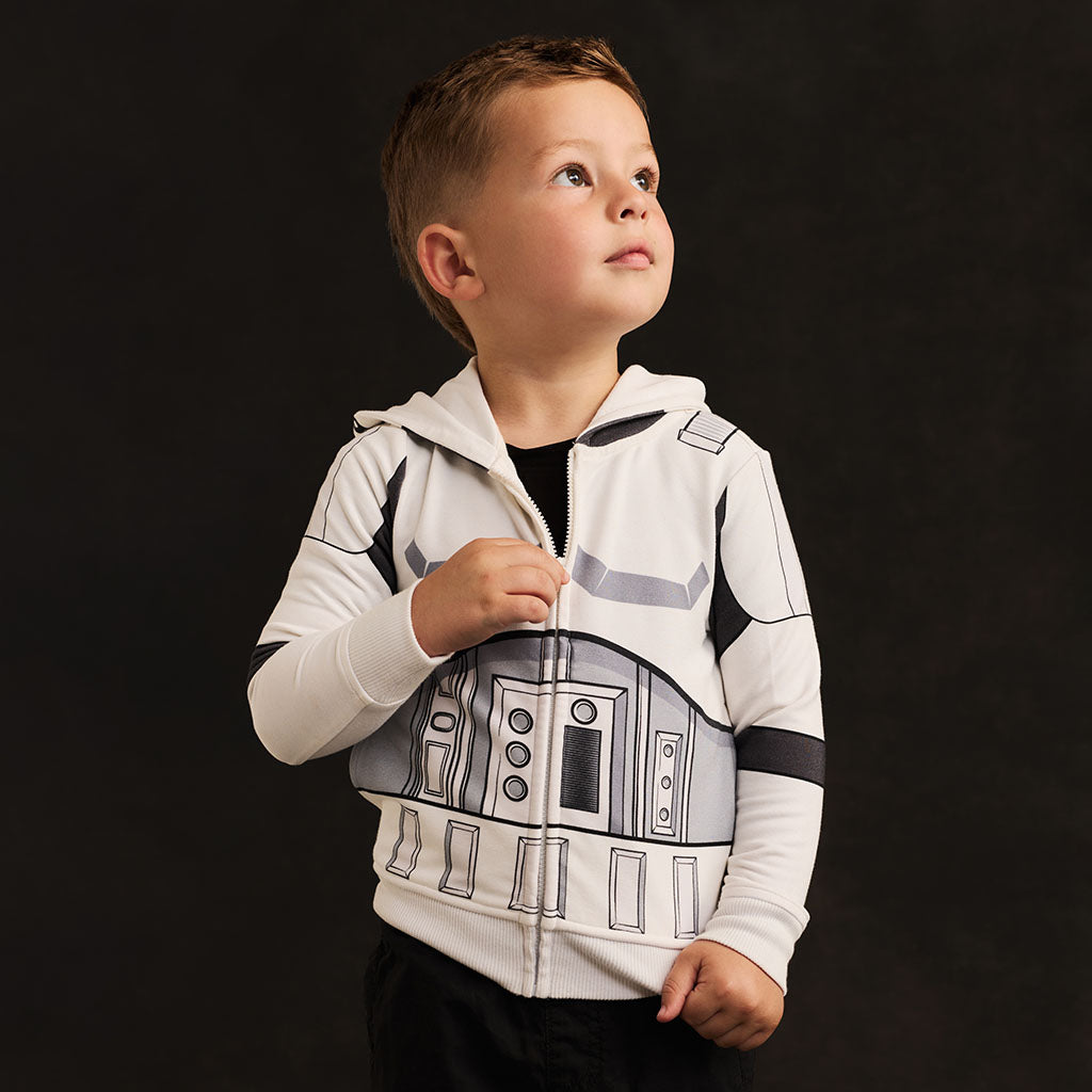 Child wearing a Star Wars-themed hoodie with R2-D2 design on a black background