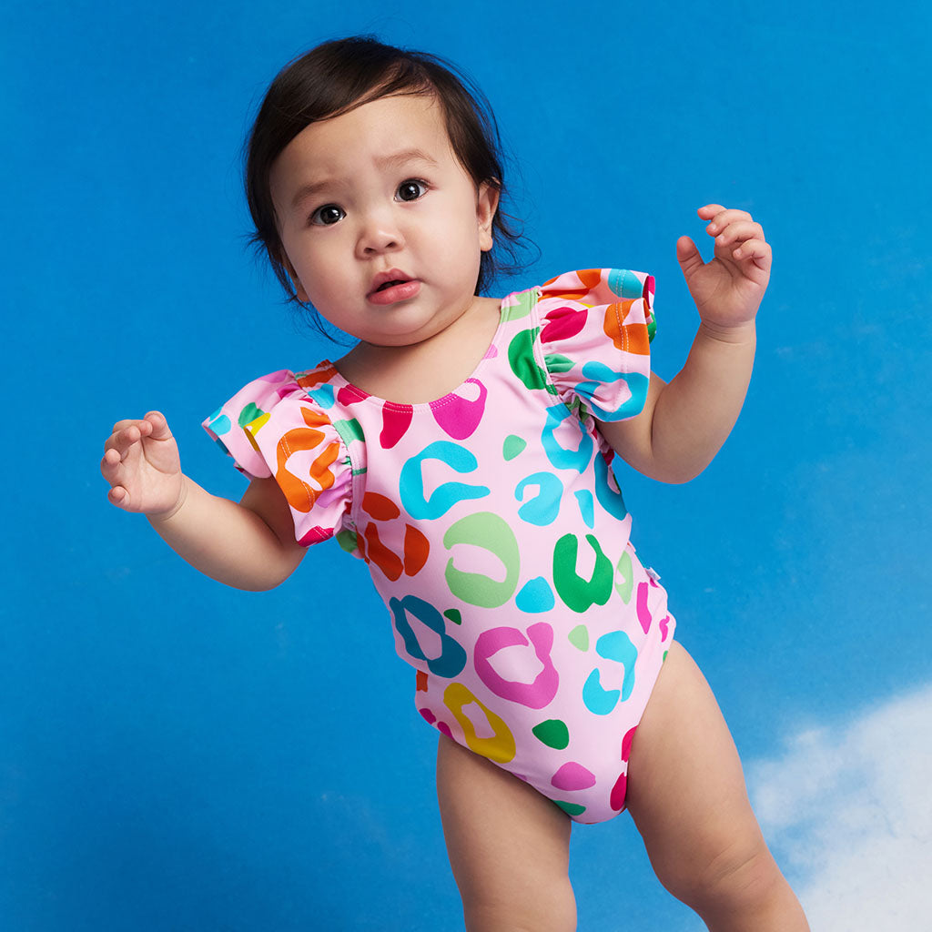 Child wearing a colorful swimsuit against a blue sky background