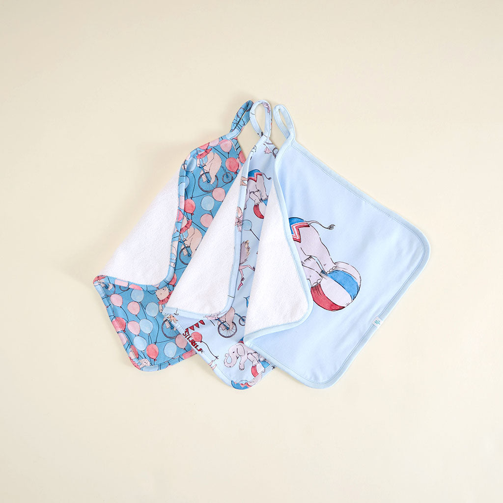 Set of 3 washcloths with circus print on a beige background.