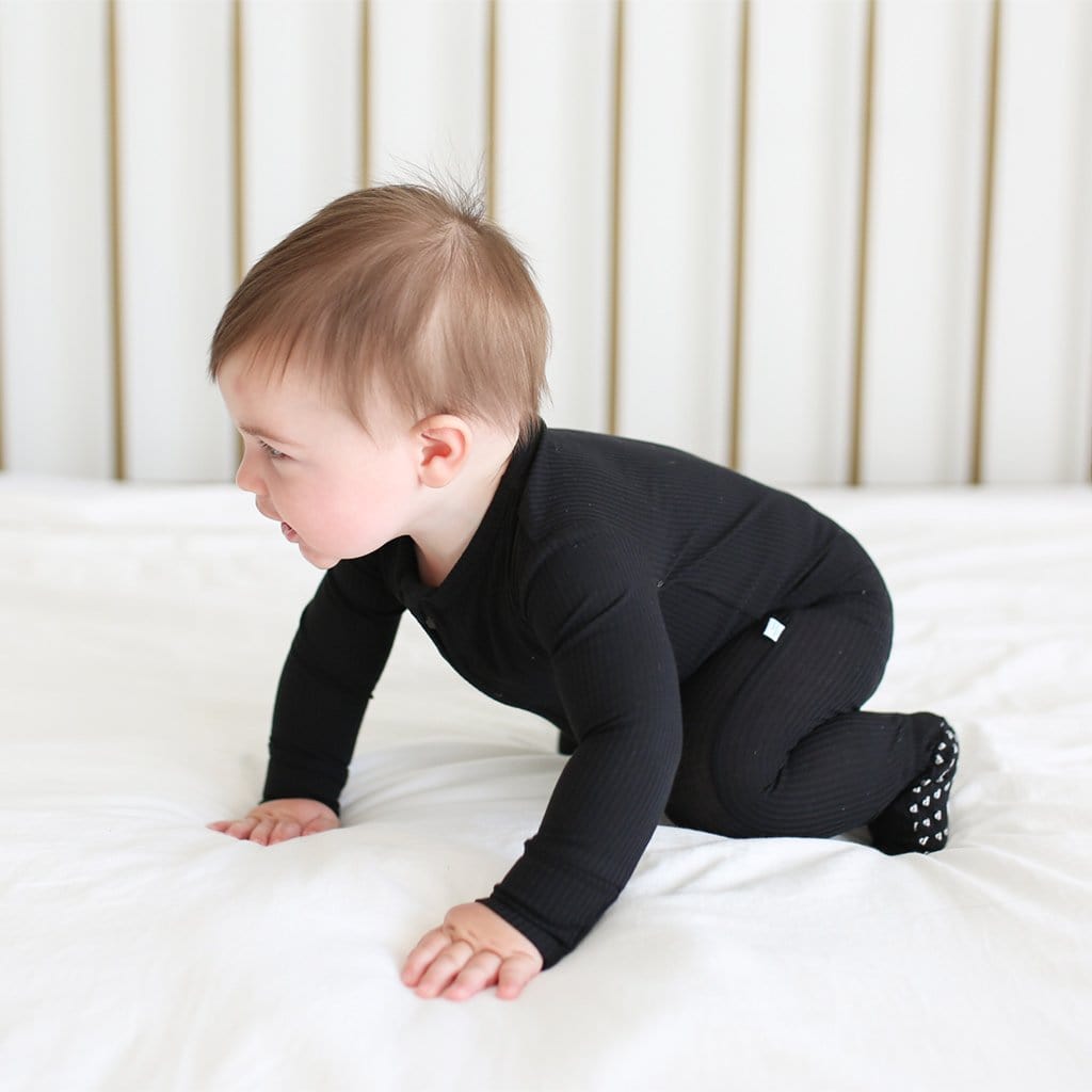 Crawling baby wearing Black Ribbed Footie Zippered One Piece